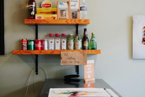 Variety of drinks on shop shelves with a no smoking sign. Indoor scene.